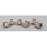 Three pairs of silver plated serviette rings each surmounted by a cast model of a wild boar. Stamped