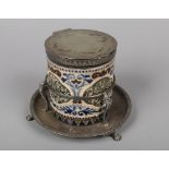 A Doulton Lambeth biscuit jar with silver plated cover and stand. With carved scrollwork in blue