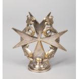 A 1920's silver plated bronze car mascot of Maltese cross form. Surmounted by a pair of coiled
