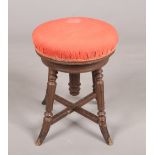 A Victorian painted rise and fall piano stool. With screw top and raised on splay supports.