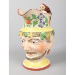 An early 19th century pearlware Bacchus mask jug. Decorated in coloured enamels, with a band of