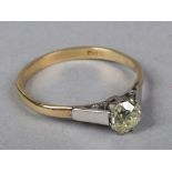 An 18 carat white and yellow gold solitaire diamond ring. Set with a round cut diamond approximately