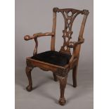 A George III Irish mahogany armchair. With curved cresting rail adorned with shell motifs, scrolling