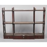 A Regency mahogany three tier breakfront wall rack. With turned supports, acorn finials, open fret