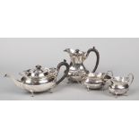 A silver four part tea service by T & H Crathorne Ltd. With pierced scalloped galleries and hardwood