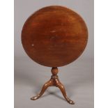 A George III mahogany snap top tripod table. Rotating on a bird cage mechanism and raised on plain