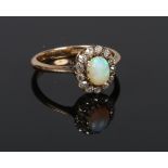 An 18 carat gold opal and diamond halo cluster ring. Gross weight 3.6 grams, size Q.