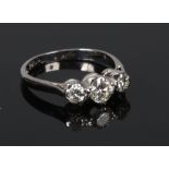 An 18 carat white gold and platinum three stone diamond ring. Set with three graduated brilliant cut