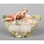 A Royal Dux posy bowl. Surmounted with the figure of a maiden and moulded with water lilys.