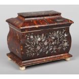 A Regency tortoiseshell tea caddy of sarcophagus form. Profusely inlaid to the front and top with