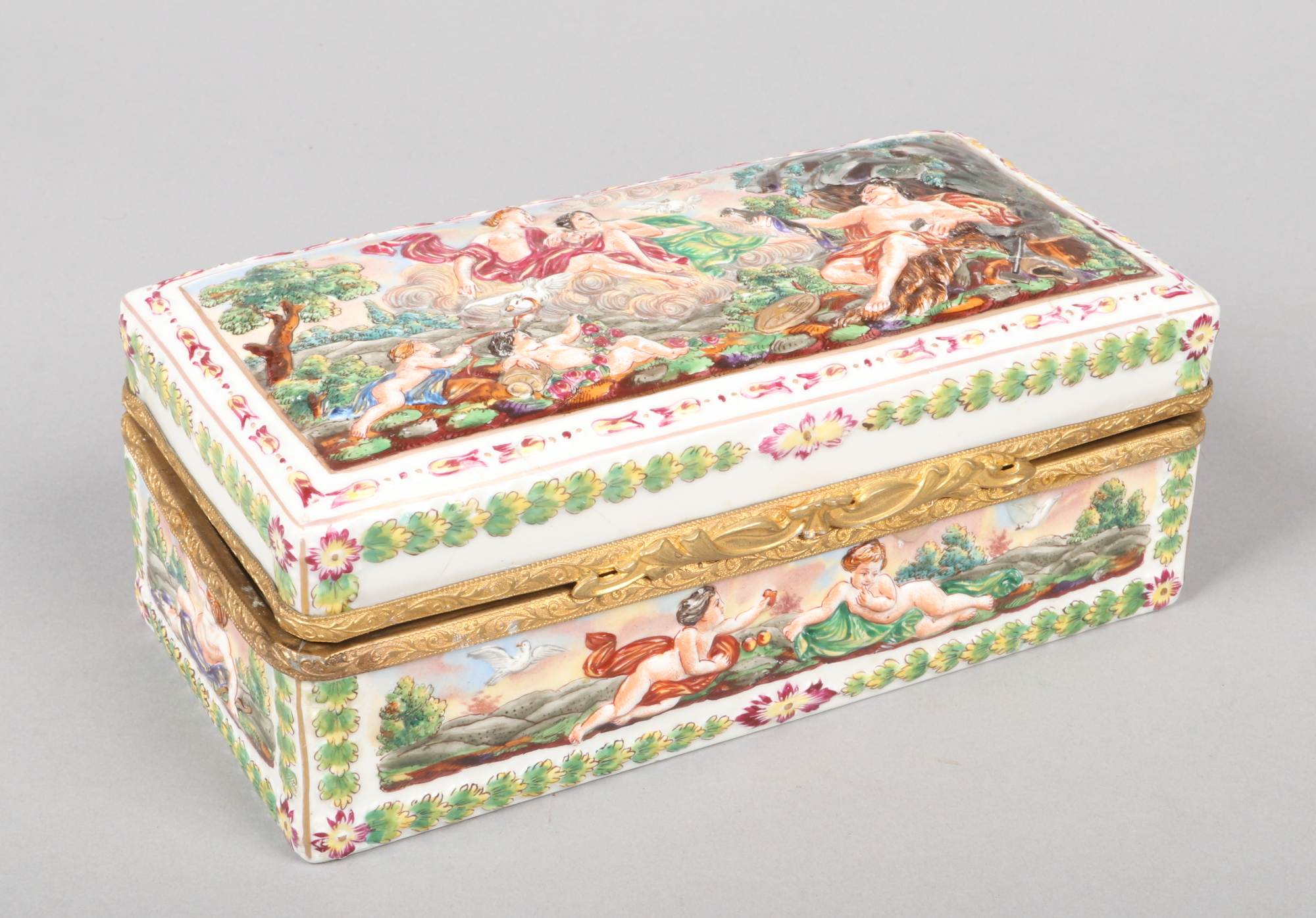 A Capodimonte casket with gilt metal mount, 21.5cm wide. Badly broken and re glued.