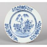 A Chinese blue and white Qianlong plate. Painted in underglaze blue with a willow tree, peonies