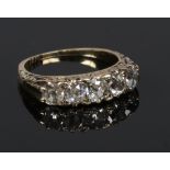 An 18 carat gold five stone diamond ring. Set with five graduated round cut diamonds. Centre stone