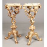 A pair of George II style marble top giltwood torchere stands. With gadrooned rims, of rustic branch