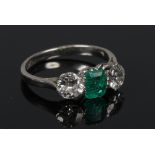 An early 20th century small platinum, emerald and diamond ring. With two brilliant cut diamonds