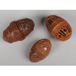 Three 19th century carved and pierced coquilla nut cotton bobbin holders of egg form. Each