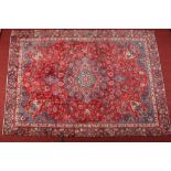 An Iranian Najafabad wool carpet. Red ground and with a central floral medallion, 250cm x 350cm.