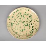 An Italian large glazed pottery platter, cream ground and with green speckles. Printed mark for