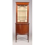 An Edwardian mahogany display cabinet of slender proportions. Astragal glazed, raised on a bow front