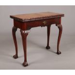 A 19th century Irish mahogany fold over tea table. With carved cabriole supports terminating on ball
