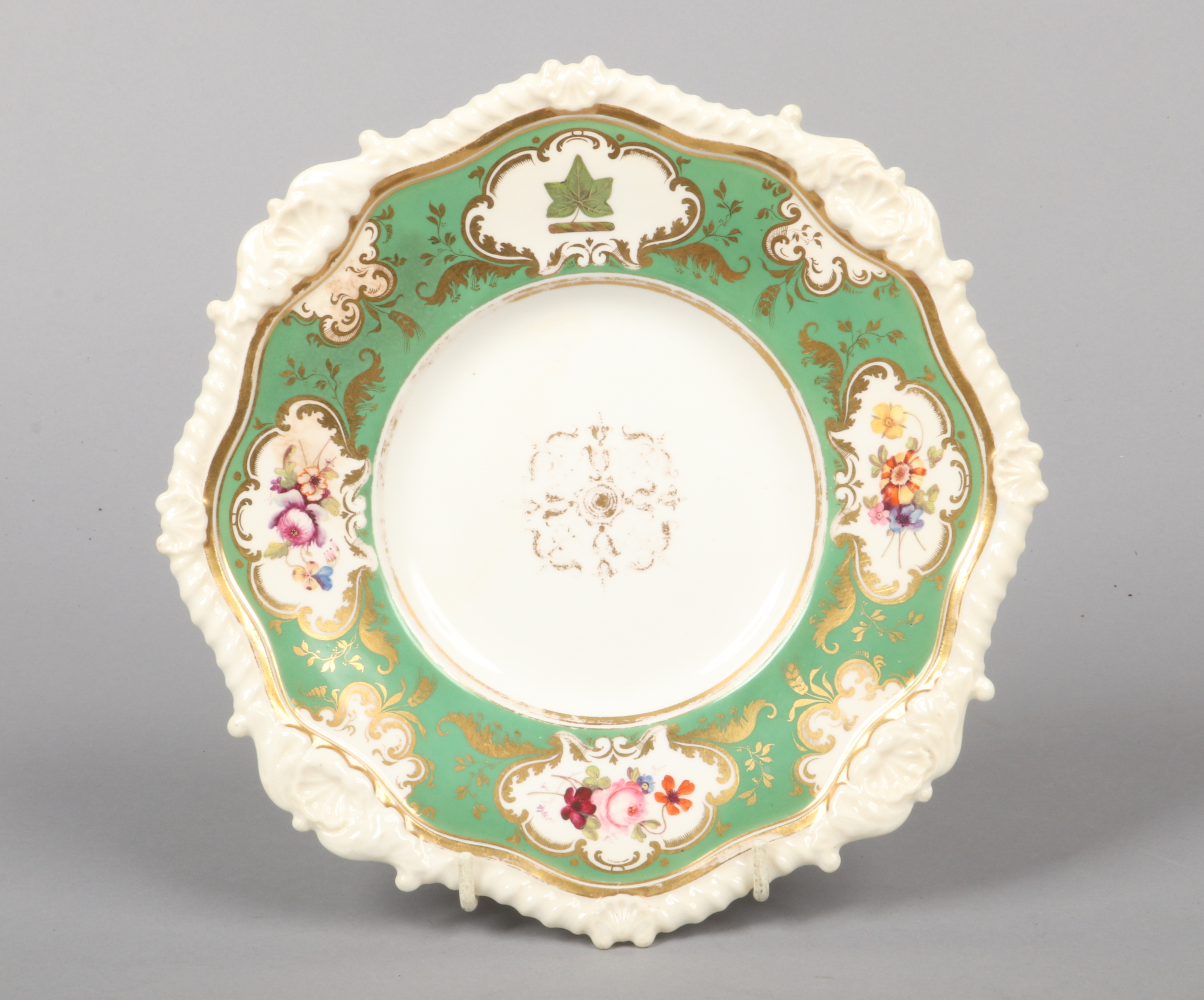 A Rockingham armorial dessert plate with shell and gadroon moulding. Having green ground border with