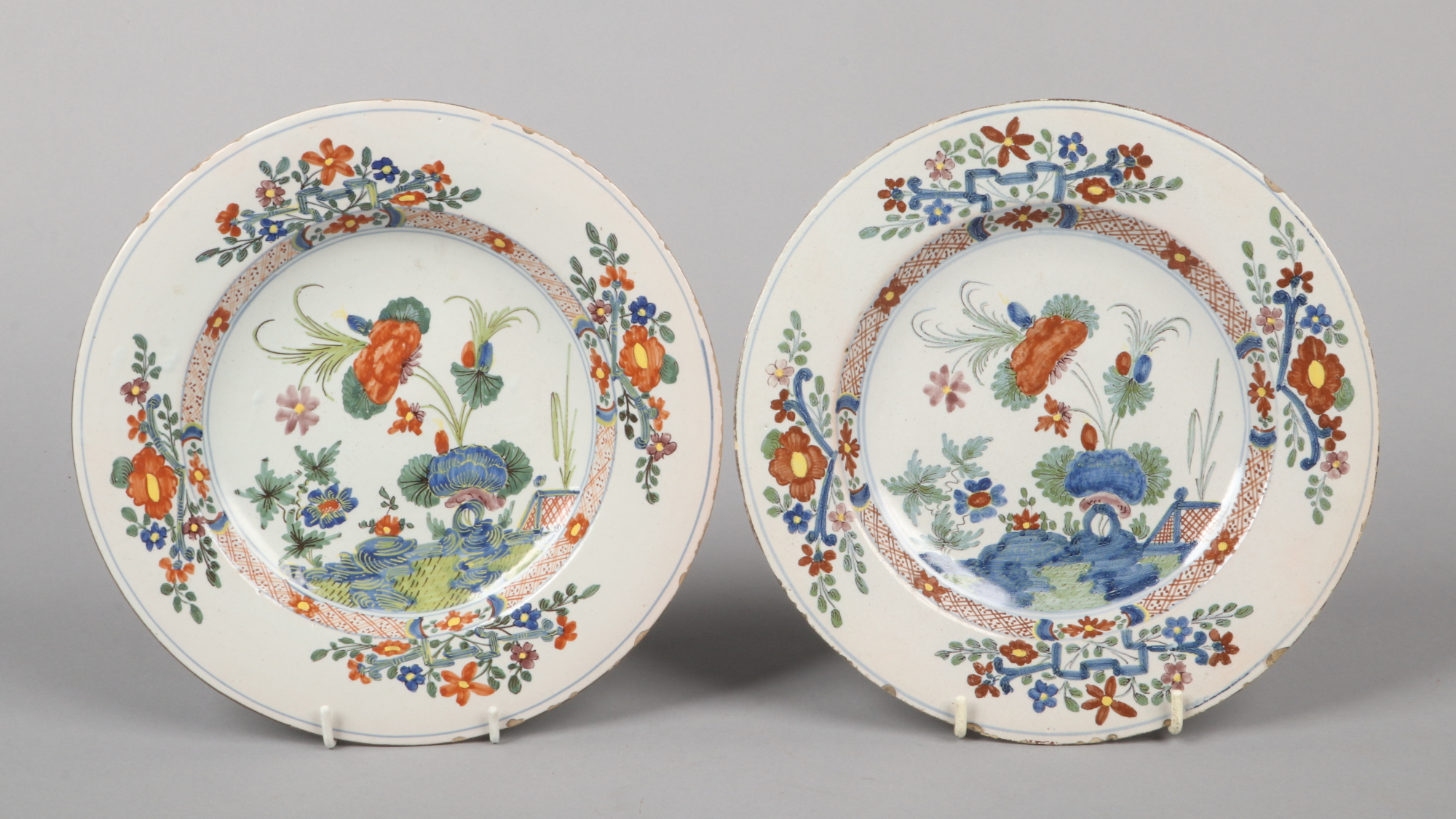 A pair of 18th century polychrome Delft plates, possibly London. Each painted with a garden