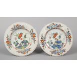 A pair of 18th century polychrome Delft plates, possibly London. Each painted with a garden