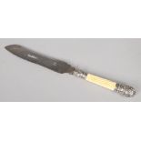 A Victorian bread knife. With carved ivory grip and silver mounts. Blade marked Alpha and