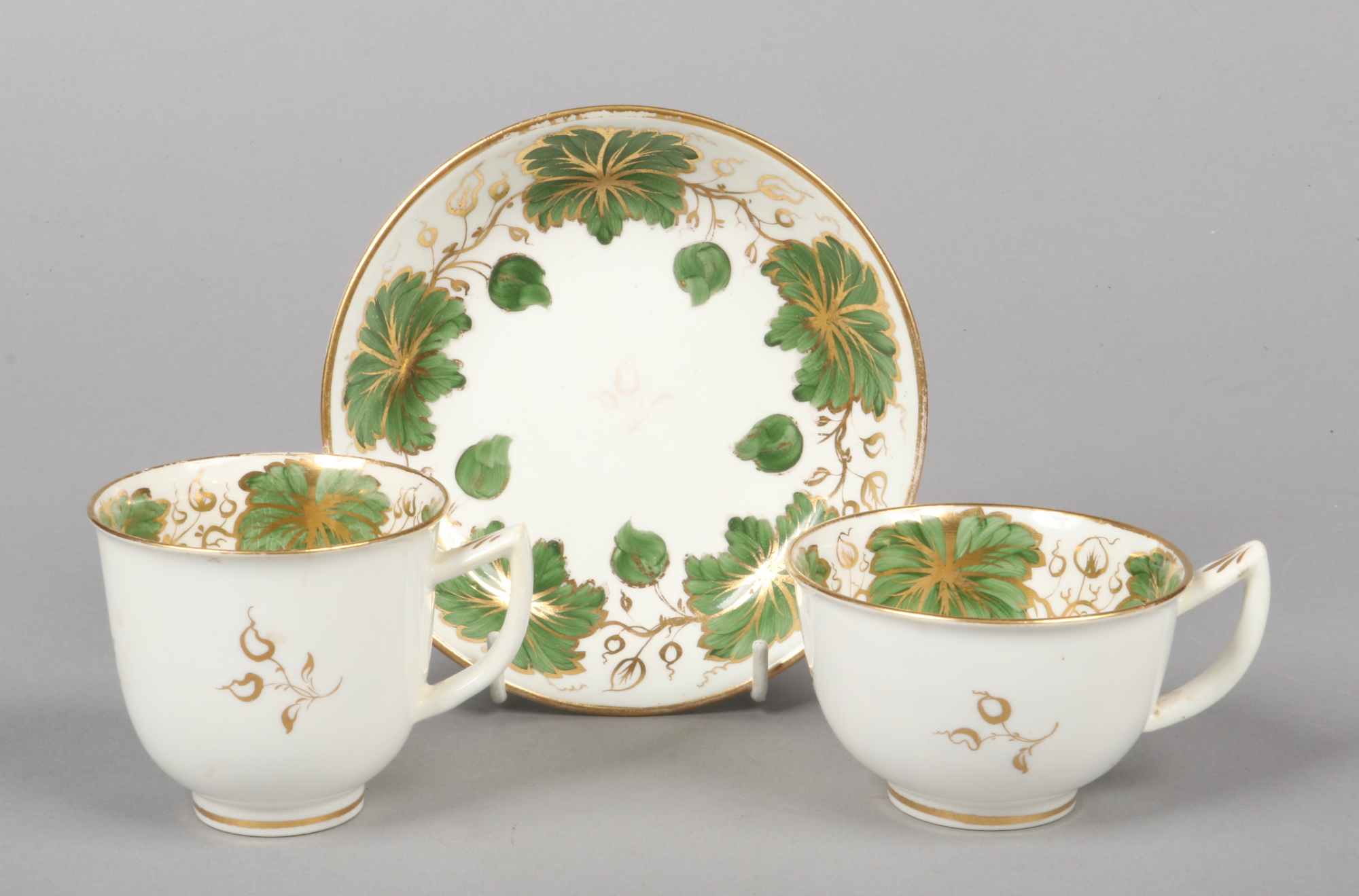 A Rockingham teacup, coffee cup and saucer of rounded type and with figure 7 handles. With green