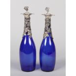 A pair of Bristol blue glass carafes with silver plated mounts decorated with vines, 34cm.
