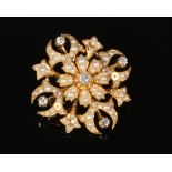 A 15 carat gold spray brooch formed as a single flower with a foliate frame. Set with five round cut