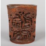 A 19th century Chinese carved bamboo brush pot. Decorated with a village scene incorporating