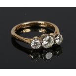 An 18 carat gold three stone diamond ring. Claw set with three graduated brilliant cut diamonds.