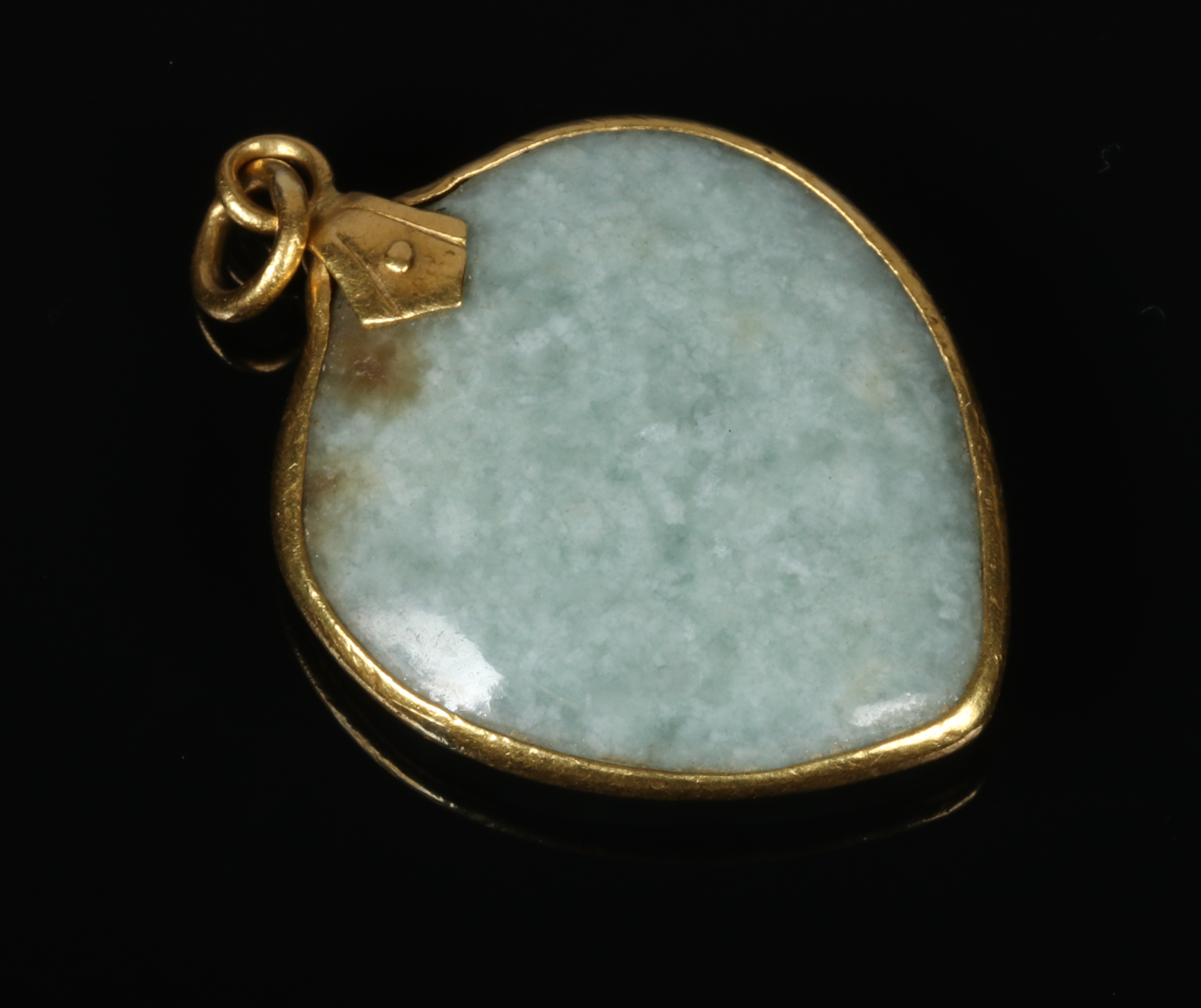 A mottled pale celadon pendant of peach form and with yellow metal mounts, 4cm. Mount ever so