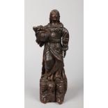 A 17th century Continental small carved wooden religious statue. Depicting a saint dressed in