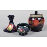 Three pieces of Moorcroft pottery. A biscuit jar and cover with pewter mount and decorated in the