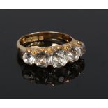 A Victorian 18 carat gold five stone ring. Set with five graduated white paste stones on a chased