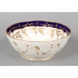 A large Rockingham punch bowl with wet blue and gilt border to the interior and a border of trailing