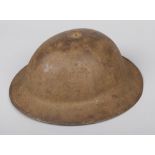 A World War I Brodie helmet. Stamped FKS No. 4. With leather liner and strap, having folded rim