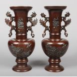 A pair of early 20th century Japanese bronze mantel vases. With flat scrolling handles formed as