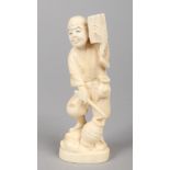 A Japanese Meiji period carved ivory Okimono. Formed as a man holding a lantern and a book and