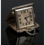 A Continental silver cased Art Deco folding bedside timepiece. With square dial signed Novelti and