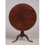 A George III mahogany fold over supper table with one piece dish top. Rotating on a bird cage