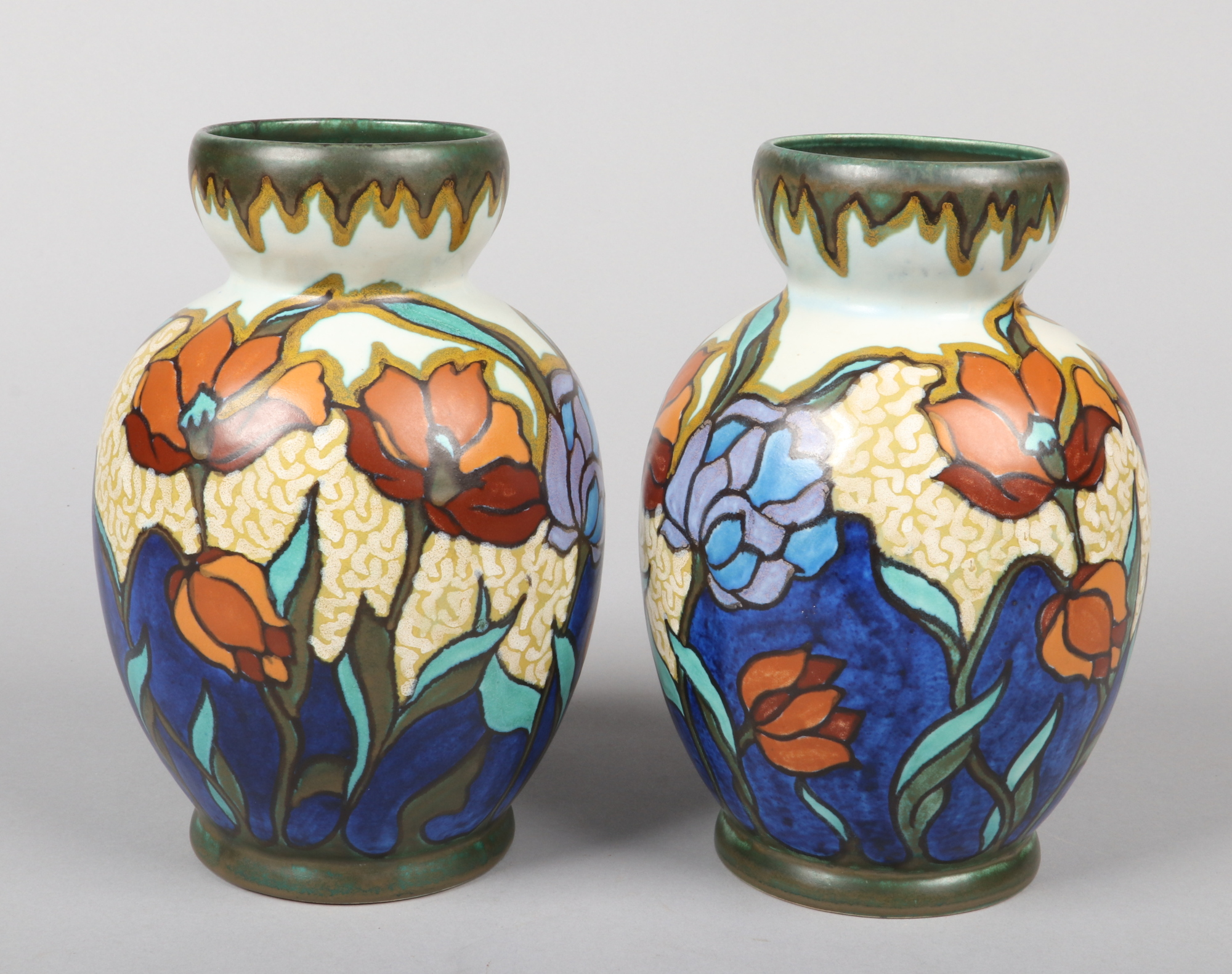 A pair of Gouda pottery mantel vases decorated with stylized poppies. Painted marks, 22.5cm. Hair