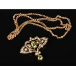 An Edwardian 9 carat gold openwork peridot and seed pearl brooch with a central lower drop and a 9