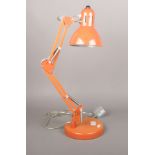 An orange Anglepoise table lamp