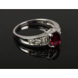 A 9ct white gold dress ring set with a large ovoid garnet and diamond shoulders. 2.7 grams, size