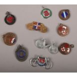 Ten vintage cycling badges and medals including enameled examples.