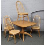 A golden dawn Ercol extending dining table along with four matching spindle back dining chairs. (