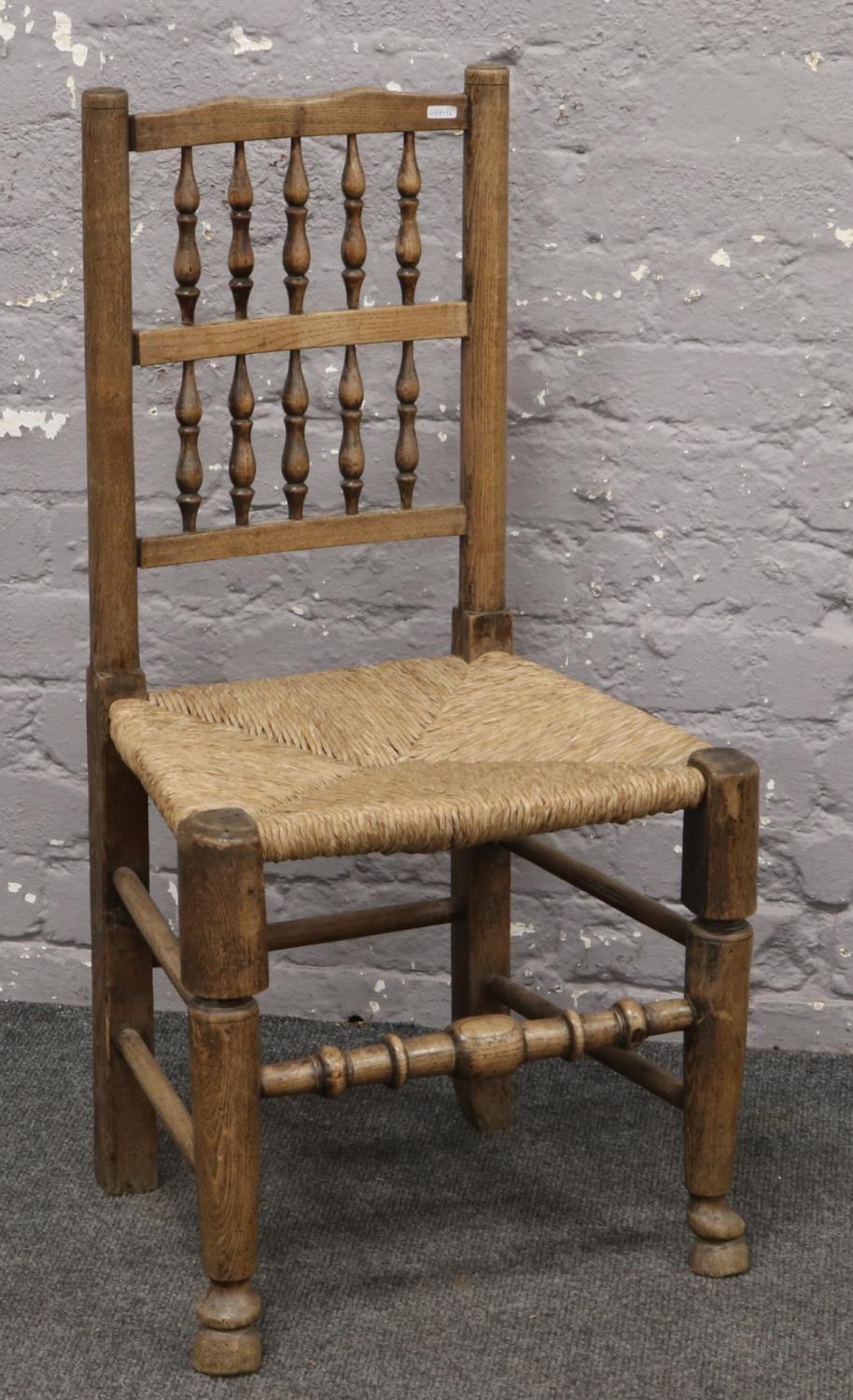 An ash and elm rush seat chair with turned supports.